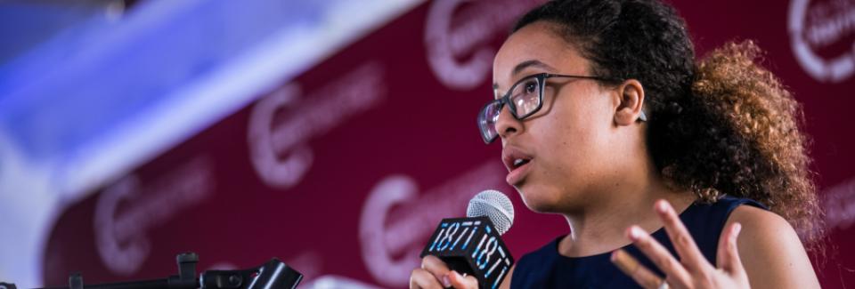 A student addresses an audience behind a podium
