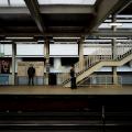 A photo of the outbound elevated platform of the Clark and Lake CTA station in Chicago. There are a few people on the platform. Photo by KE ATLAS on Unsplash