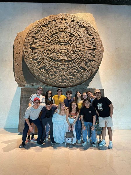 friends gather in front of mexican monument