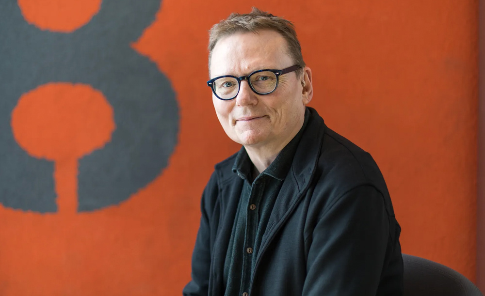 James Robinson standing in front of an orange wall