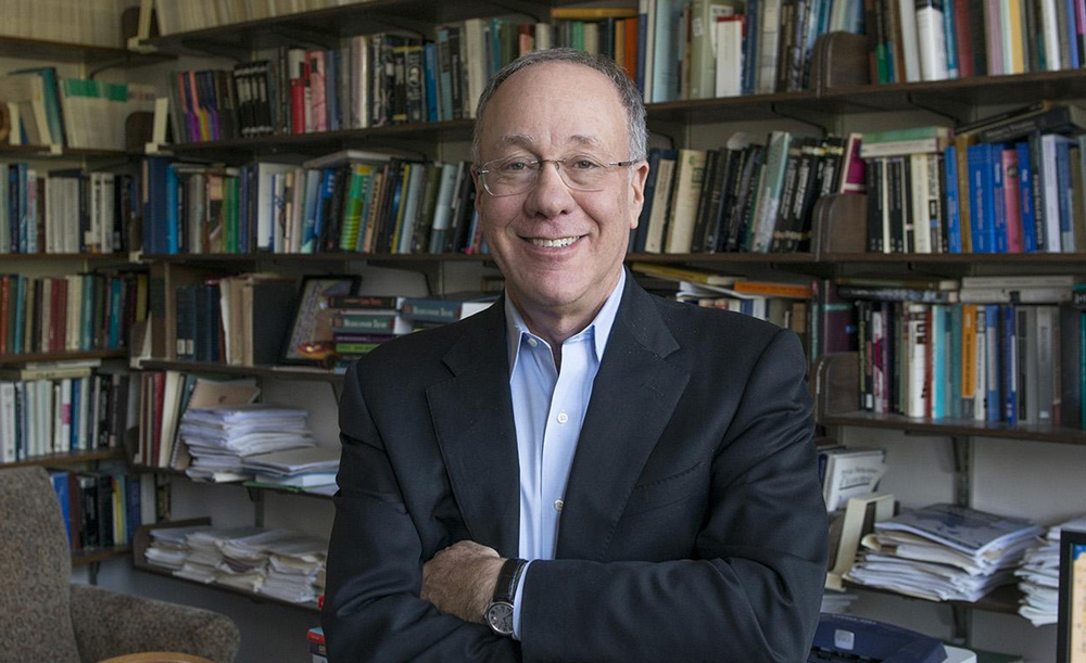 Roger Myerson standing in front of a shelf of books