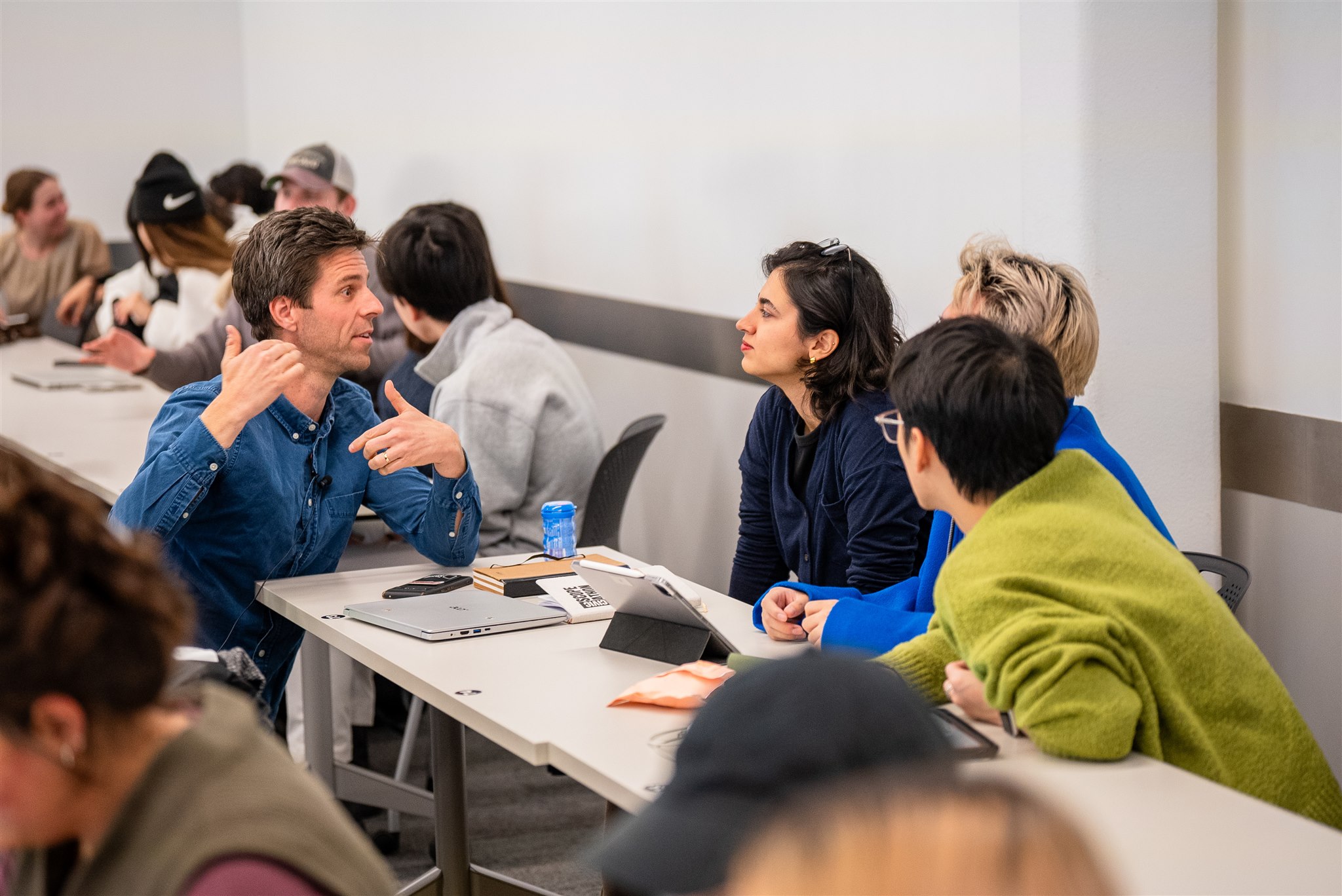 Students talking with their teacher in the classroom