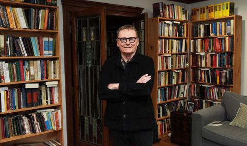 James Robinson standing in front of a bookshelf at home