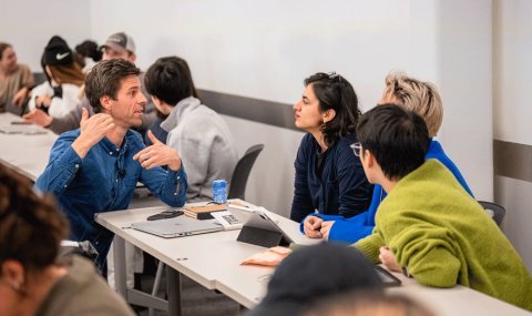 Students talking to a teacher in the classroom