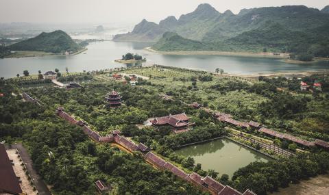 image of buildings with asian architecture amidst hilly region surrounded by forest