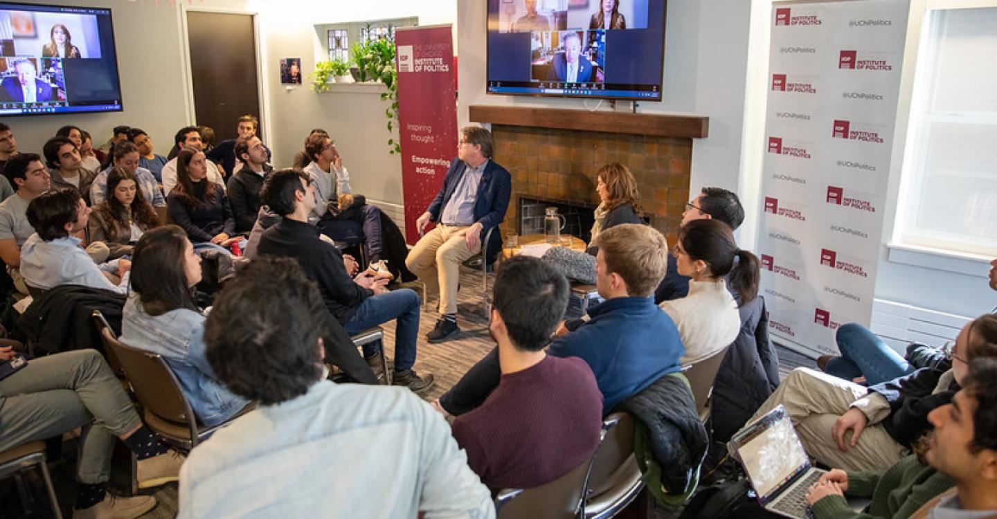 Students gather around panelists in front of a fireplace at the UChicago Institute of Politics