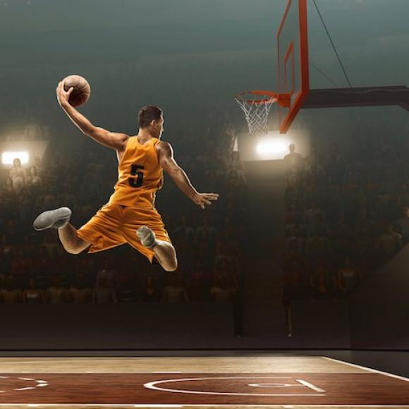 A basketball player goes for the goal.