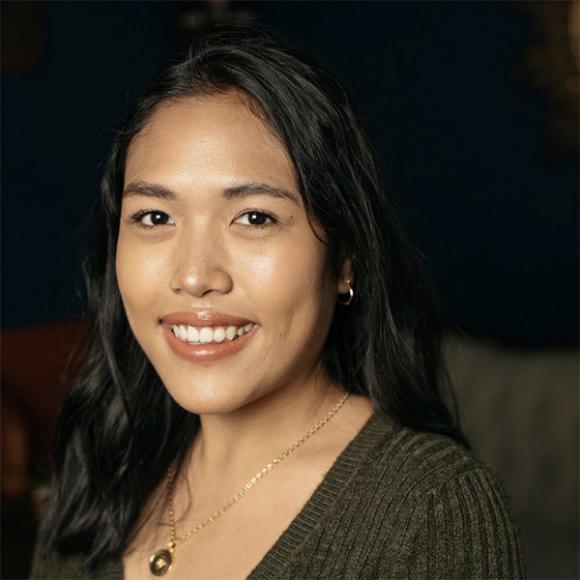 Sharlene Guiriba in a green shirt and necklace smiling