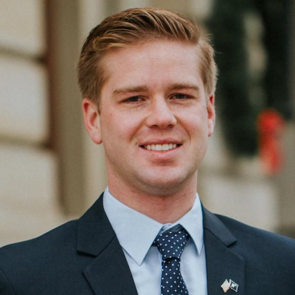 Andrew Beeler smiling in a blue suit jacket and blue tie
