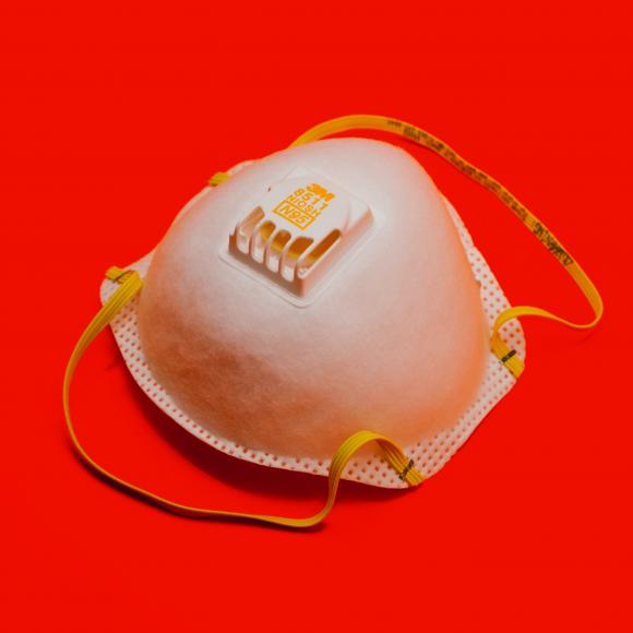 A photo of an N-95 mask on a red background