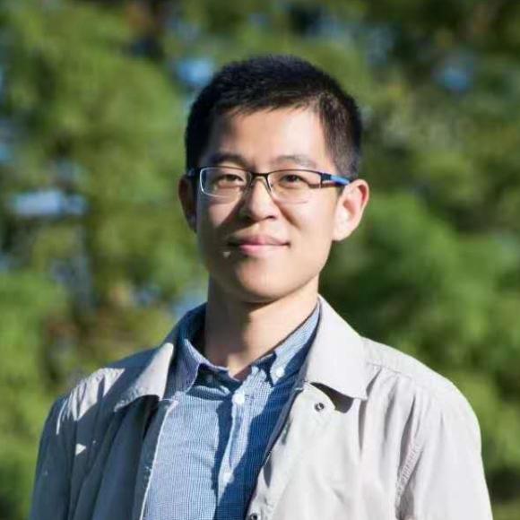 Spencer Zhang, standing in front of trees