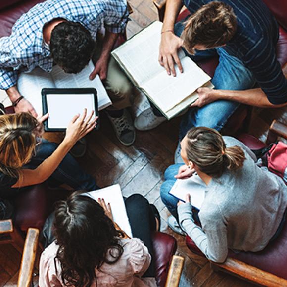 students gathered around books arial view