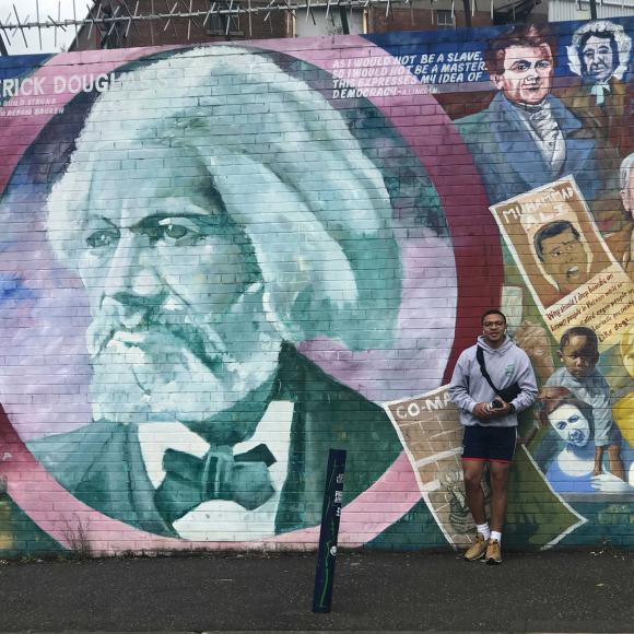 A photo of David Johnson in front of a mural.