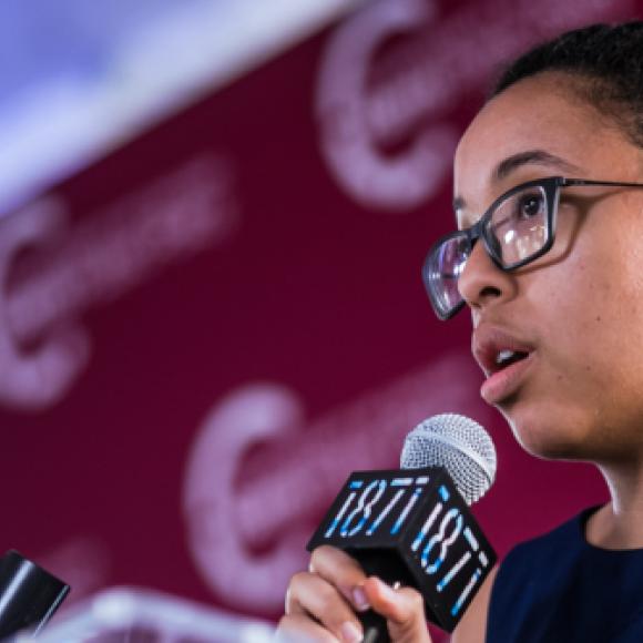 A student addresses an audience behind a podium