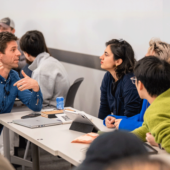 Students talking to a teacher in the classroom